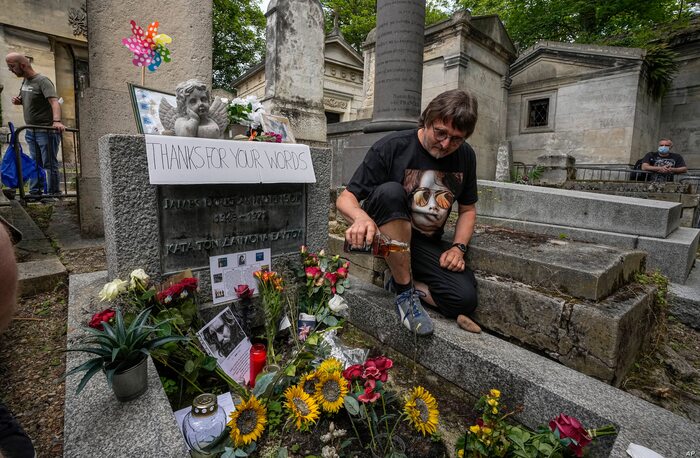 Torsten Marquardt of Germany pours some whiskey on the tomb of rock singer Jim Morrison at the Pere-Lachaise cemetery in Paris, July 3, 2021.