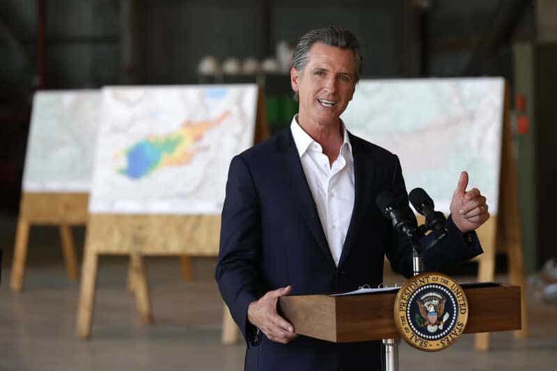 California Gov. Gavin Newsom delivers remarks after a helicopter tour of the Caldor Fire area with President Biden on Monday in Mather, Calif. Biden then went to the Los Angeles area to participate in a No on Recall campaign event with Newsom.