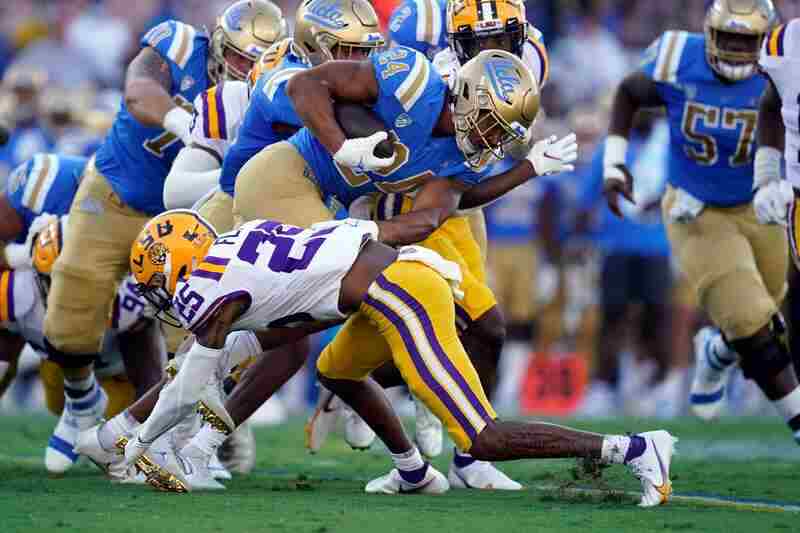 UCLA running back Zach Charbonnet (24) is tackled by LSU cornerback Cordale Flott (25) during the first half of an NCAA college football game Saturday, Sept. 4, 2021