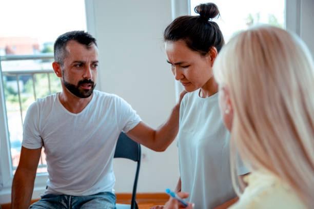 Giving Tender and love to friend in the rehabilitation clinic Man Consoling Asian Woman in group psychotherapy session. addiction rehabilitation center stock pictures, royalty-free photos & images