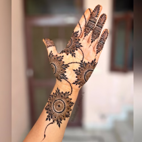 Half mandala at wrist with leafy trail to finger.