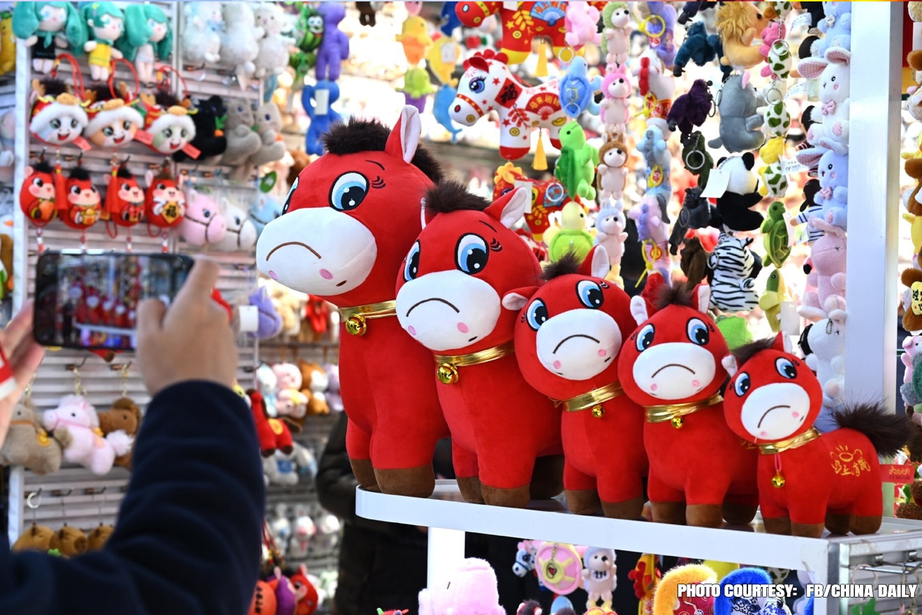 Shop owner Zhang Huoqing showcases the trending “Crying Horse” plush toy 