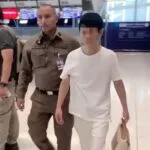 A Chinese fugitive wanted on an Interpol Red Notice is seen along with some of the evidence seized by immigration police officers at Suvarnabhumi airport